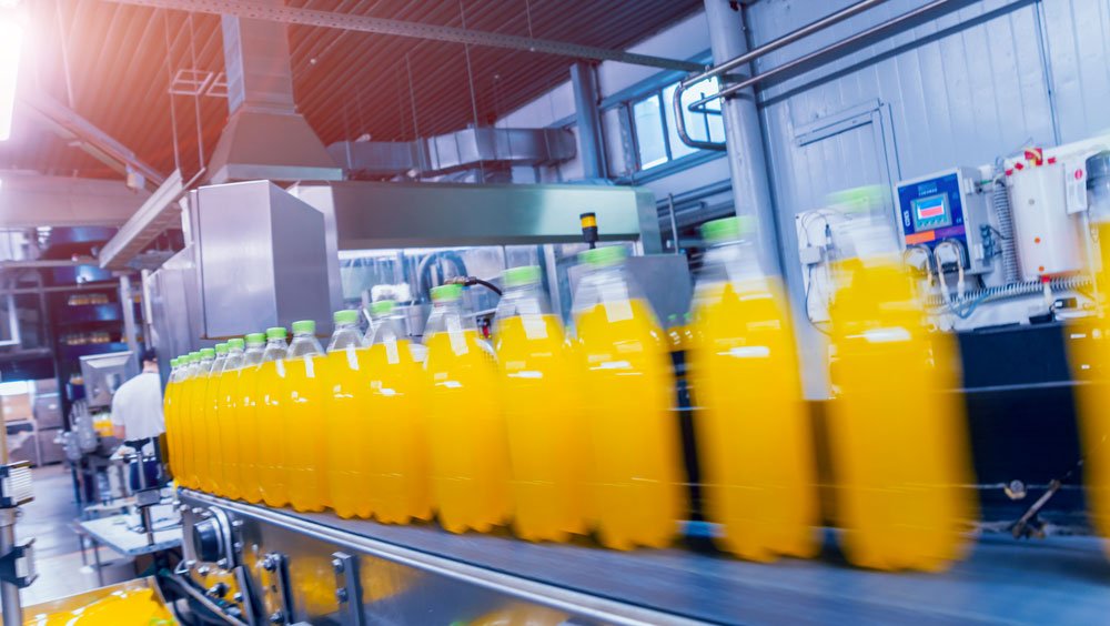Orange Juice bottle on conveyor 1000x564 1